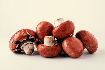 Fresh mushrooms on a light background. Brown champignons. Toned image of a bunch of mushrooms.