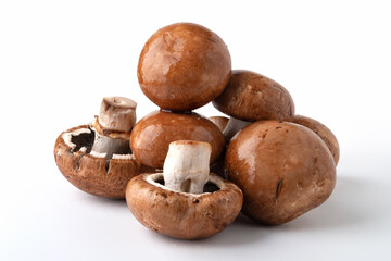 Wet mushrooms on white background. Brown champignons. Bunch of mushrooms.