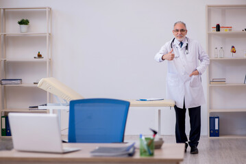 Old male doctor working in the clinic