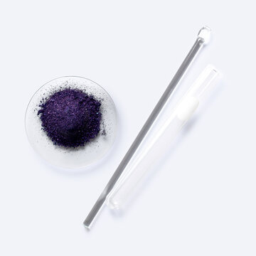 Cosmetic chemicals ingredient on white laboratory table. Potassium permanganate (KMnO4), stirring rod and test tube.