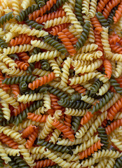 Tricolor, dry and raw pasta, food for background