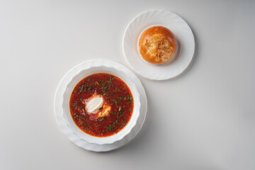 Borscht with sour cream in a white plate top view