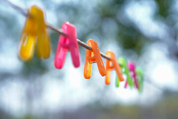 Colorful tongs are hanging on the clothesline 