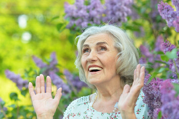 happy  senior beautiful woman on  lilacs background