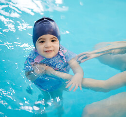 Kid float in pool water