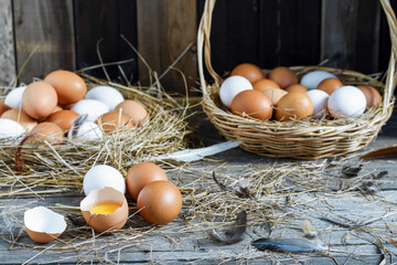 Fresh eggs are placed on a wooden table and fresh eggs are placed in a basket in an organic farm.