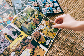 Fototapeta premium Woman reads manga comic book on the carpet at home. Rostov-on-Don, Russia. 18 March 2021