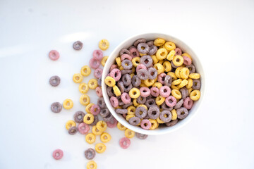 Colored flakes in a plate and sprinkled on a white background