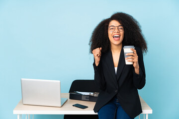 African american business woman working in her workplace celebrating a victory in winner position