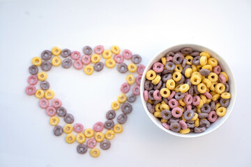Colored flakes in a plate and in the form of a heart on a white background.