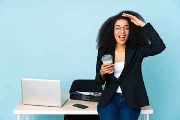 African american business woman working in her workplace with surprise expression