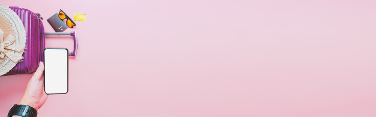 online booking travel and pay concept from smartphone and suitcase with summer collection on pink background.