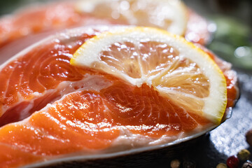 Steak raw salmon with lemon, thyme on a dark background. Top view