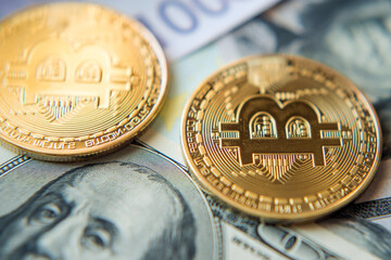 Two bitcoins on denominated dollars and euros in a sunny light (Investment, course change - concept)