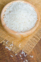 Organic Thai Jasmine rice grain in wooden bowl.