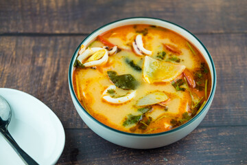 Fresh squid tom yum soup in bowl
