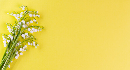 Bouquet of spring lilies of the valley on yellow, top view, flat layer, place for text, copyspace.