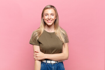young blond pretty woman laughing shyly and cheerfully, with a friendly and positive but insecure...