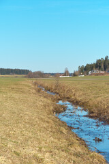 b&auml;uerliche landschaft mit wiesen, bach , wald und blauen himmel