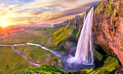Charming beautiful waterfall Seljalandsfoss in Icelandat sunset. Exotic countries. Amazing places. Popular tourist atraction.