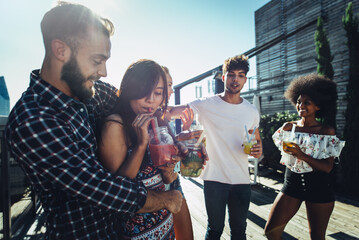 Group of friends having fun on the rooftop of a beautiful penthouse