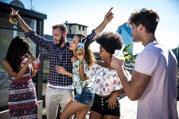 Group of friends having fun on the rooftop of a beautiful penthouse