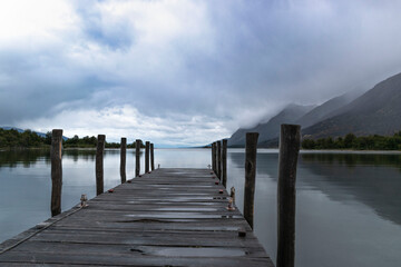 Naklejka premium pier in the quiet lake and cloudy sky