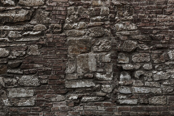 Old grungy retro grimy brick wall of ancient city. Uneven dirty pitted peeled surface brickwork of cellar worn. Ruined solid bumpy stiff blocks. Hard messy ragged holes brickwall for 3D grunge design