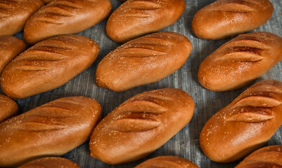 Automatic line for the production of bakery products with a loaf on a conveyor belt, equipment in the workshop of a confectionery factory, industrial food production. Production oven at the bakery.