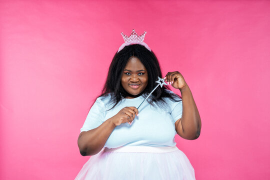 Image of a beautiful woman posing in a fairy costume on a pink background