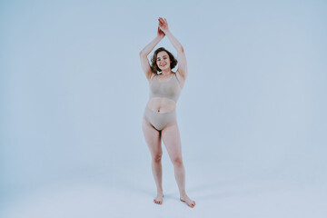 Image of a beautiful woman posing in studio wearing lingerie. Concept about body positivity and self acceptance