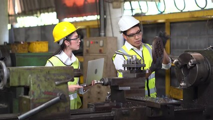 asian industrial Engineer manager man demonstration and training mechanic worker woman operating industrial lathe machine and checking with laptop computer in heavy industry manufacturing factory .