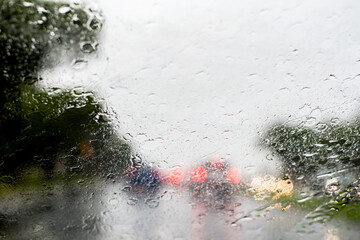 Blurred defocused image of heavy torrential rain through the windscreen. Rainfall flash flooding background