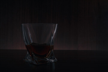 A glass of alcohol on the table in the dark