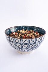 five pepper seeds on blue bowl isolated