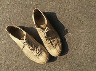 Top view pair of old white vintage canvas sneakers shoes on cement ground.