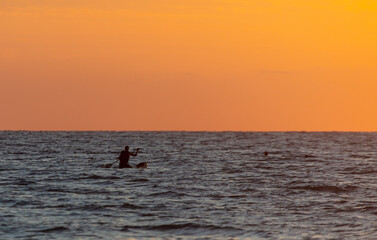 Fototapeta premium A man floats on a board in the sea