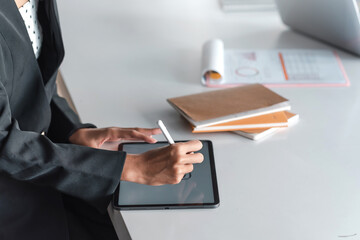 Close up of businesswomen holding pen to tablet take notes at the office.