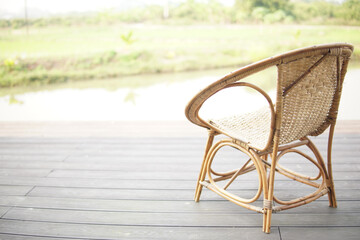 wicker rattan chair on balcony terrace patio near pond