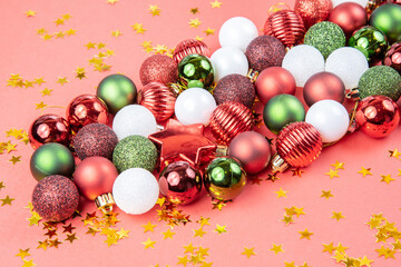 Green, white and red toy balls, and stars on a red paper background. Beautiful new year or christmas card