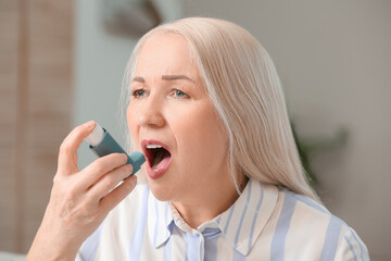 Mature woman with inhaler having asthma attack at home