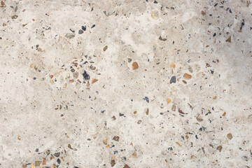 Abstract texture of light concrete with colored pebbles