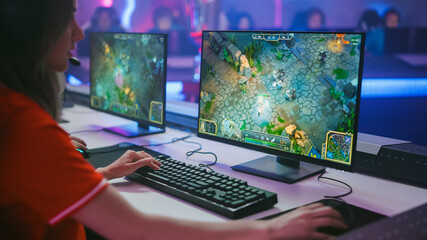 Pro Girl Plays Computer Game Plays RPG Strategy on a Championship. Diverse Esport Team of Pro Gamers Play in Mock-up Video Game. Stylish Neon Cyber Games Arena. Over The Shoulder Shot © Gorodenkoff