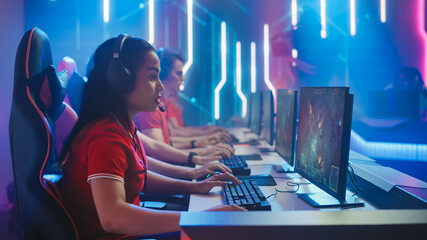 Pro Girl Plays Computer Game Plays RPG Strategy on a Championship. Diverse Esport Team of Pro Gamers Play in Mock-up Video Game. Stylish Neon Cyber Games Arena. Side View Shot
