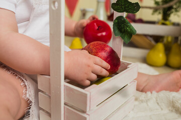 close-up of a child holding apples in the background with a basket