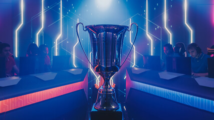 Two Esport Teams of Pro Gamers Play to Compete in Video Game on a Championship. Stylish Neon Cyber Games Online Streaming Tournament Arena with Trophy in the Center. © Gorodenkoff