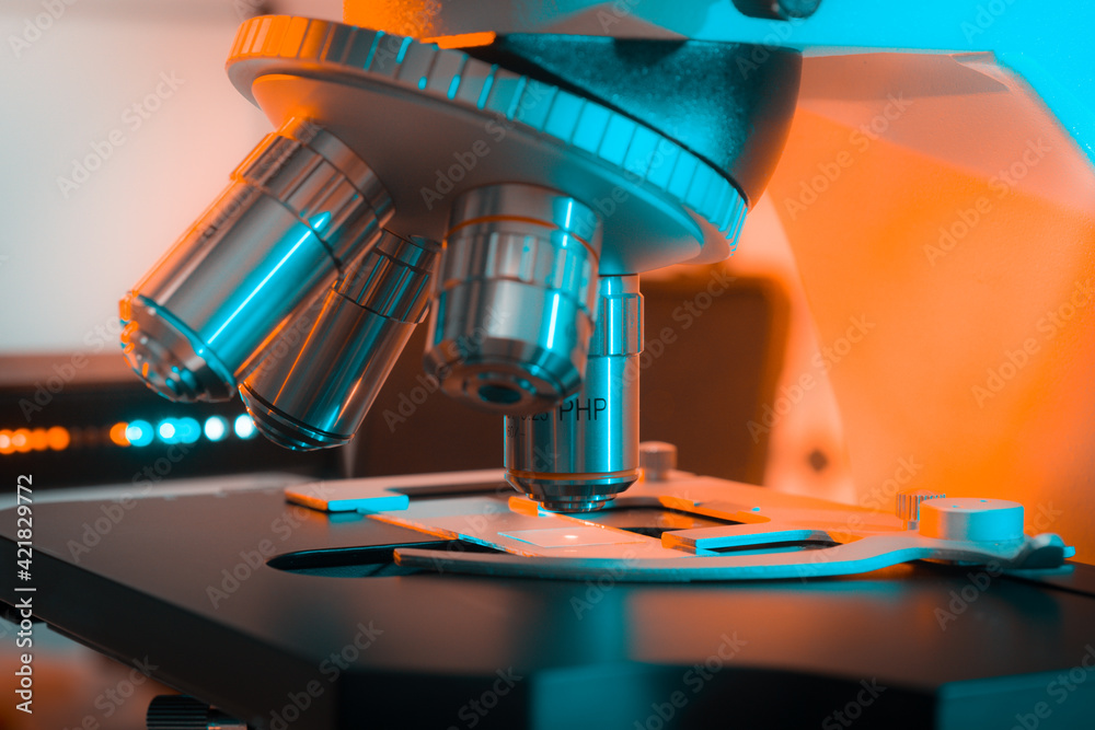 Sticker Toned photo of a backlit microscope lens in a science laboratory