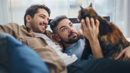 Happy Gay Couple in Love Play with Gorgeous Purebred Cat. Cheerful Young Boyfriends Spending Time...
