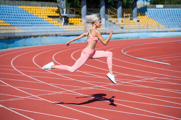 Fototapeta premium athletic woman in fitness wear running on stadium, speed