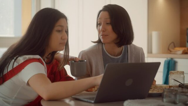 Happy Lesbian Couple Having Pancakes and Croissants For Breakfast Use Laptop. Sunday Morning Two Girlfriends in Love have Fun Talking, Watching Videos, Doing e-shopping. Partners Share Tender Moments